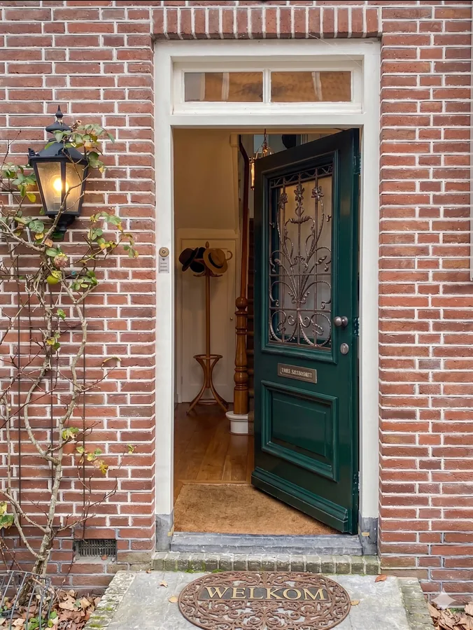 Een openstaande groene voordeur.